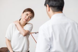 肩こりを相談する女性